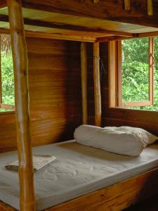 a bunk bed in a cabin with two windows at Mentawai Surfing Fishing in Masokut +25 photos