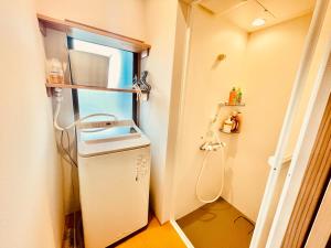 a small bathroom with a sink and a washing machine at のどかな風景と綺麗な星空の宿 "キノイロ ミニマル" "Kinoiro Minimal" in Ainan +28 photos