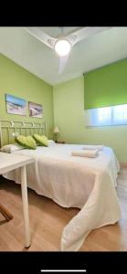 Una cama grande en una habitación con paredes verdes. en Atardeceres en Bajoguía, en Sanlúcar de Barrameda