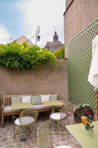 a patio with a bench and tables and chairs at Le Clos Haton - HAUTVILLERS in Hautvillers
