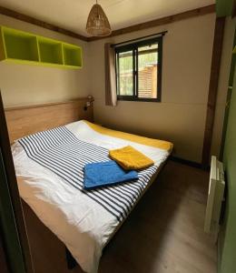 une petite chambre avec un lit avec des serviettes dessus dans l'établissement Chalet cozy dans Village au cœur des pins, parking gratuit, à Onesse-et-Laharie