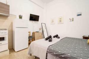 eine Küche mit einem weißen Kühlschrank und einem Bett in der Unterkunft Сozy and traditional - EC Studios in Larnaka