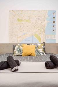 a bed with pillows and a map on the wall at Сozy and traditional - EC Studios in Larnaka