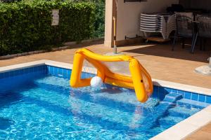 a yellow inflatable slide in a swimming pool at Villa Buroli with Pool, Sauna and Jacuzzi in Buroli +28 photos