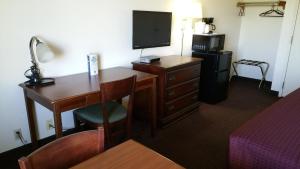 Una habitación de hotel con un escritorio y un televisor. en Hoosier Inn- Portland, en Portland 3 fotos más