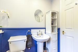 a bathroom with a white toilet and a sink at Homely 4 Bedroom House Addlestone in Addlestone +5 photos