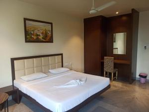 a bedroom with a large white bed in a room at Hotel Shiva Palace in Sivasagar