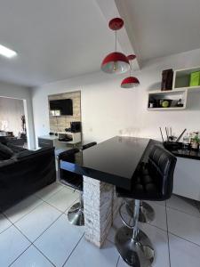 a kitchen and living room with a black table and chairs at Casa disponível in Ibirubá