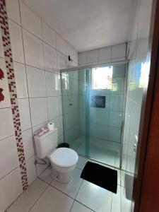 a bathroom with a toilet and a glass shower at Casa disponível in Ibirubá