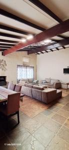 a large living room with a large couch and chairs at Thabametsi Farm in Maanhaarrand