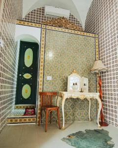 a room with a table and a chair and a mirror at DAR EL HAMRA in Mahdia +93 photos