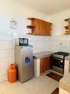 a kitchen with a refrigerator and a stove at MJ Homes Mombasa - Cosy and lavish 2 bedroom apartment master ensuite unit in Mombasa