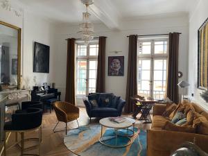 a living room with couches and chairs and a table at La chambre d Olympe Chambre d hôtes au cœur de la cité historique in Montauban