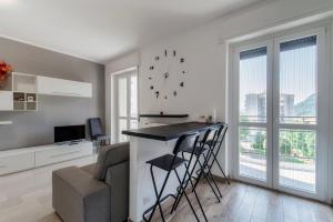 a living room with a bar with a couch and a clock at Beyond Como by Quokka 360 - flat 10 minutes from the centre of Como in Lipomo +22 photos