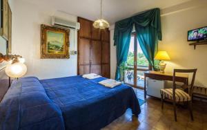 a bedroom with a blue bed and a desk and a window at Hotel Garden in Nuraminis