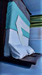 a bed with four pillows on top of it at Kabs guest house in Kisubi