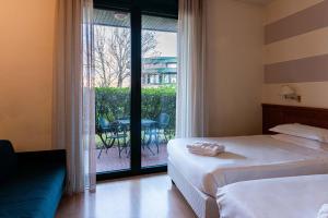 a bedroom with a bed and a balcony with a table at Phi Hotel Emilia in Ozzano dell'Emilia +44 photos