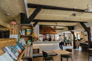 a restaurant with a counter and tables and chairs at Groepsaccommodatie met hottub en sauna | 18 personen in Neede