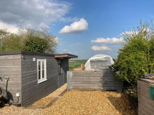 a small house next to a fence with a dome at The Pigsty in Winford