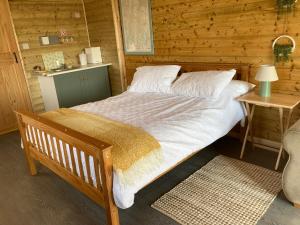 a bedroom with a bed in a wooden cabin at The Pigsty in Winford