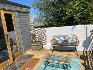 a patio with a couch and a coffee table at The Pigsty in Winford