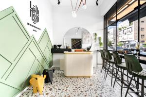 a restaurant with green chairs and a white counter at Levinski Market Hotel in Tel Aviv +83 photos