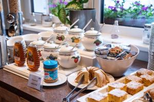 a buffet with desserts and tea pots and bread at COOEE alpin Hotel Dachstein in Gosau +111 photos