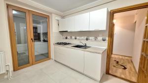 a kitchen with white cabinets and a sink at Apartament cu vedere panoramica in Galaţi