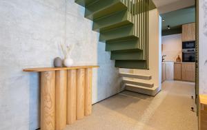 une cuisine avec un comptoir en bois et des escaliers verts dans l'établissement Chioni House, à Kʼumlistsʼikhe