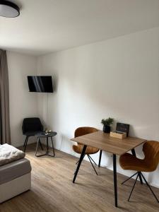 a living room with a table and chairs and a tv at Queen Apartment in Metzingen