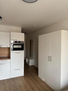 a kitchen with white cabinets and a stove at Queen Apartment in Metzingen