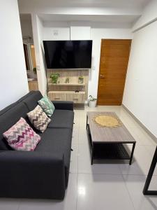 a living room with a black couch and a coffee table at Hermoso departamento, excelente ubicación. in Salta