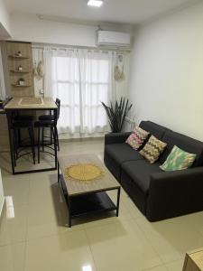 a living room with a black couch and a table at Hermoso departamento, excelente ubicación. in Salta
