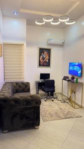 a living room with a couch and a desk at Percy Homes in Lekki +7 photos