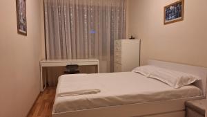 a bedroom with a bed and a dresser and a window at Apartament cu vedere panoramica in Galaţi