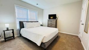 a bedroom with a bed and a television in it at Vacay escape, rooms in Charlotte in Charlotte