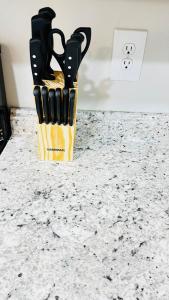 a knife block filled with knives sitting on a counter at Vacay escape, rooms in Charlotte in Charlotte