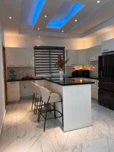 a kitchen with a white island with stools at Casahermosa in Santo Domingo