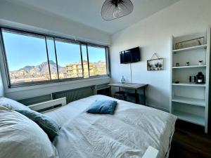 a bedroom with a bed and a large window at Le petit chartreux in Grenoble