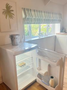 an empty refrigerator with its door open in a kitchen at The Country club - Woodland cabin 
