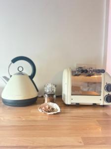 a kitchen counter with a toaster and a plate of food at The Country club - Woodland cabin  +8 photos