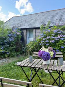 a wooden table with a vase of flowers on it at The Country club - Woodland cabin 