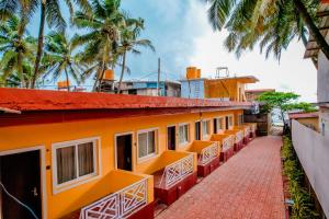 ゴカルナにあるCozy Gokarna Beach Stayのヤシの木を背景にしたオレンジ色の建物の列