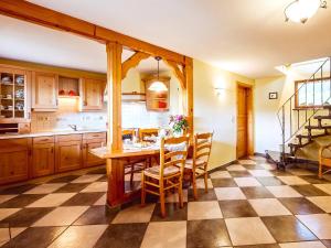 a kitchen with a table with chairs and a checkered floor at Ferienhaus Am Sonnenstein in Holungen