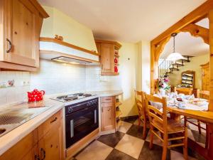 a kitchen with a stove and a table with chairs at Ferienhaus Am Sonnenstein in Holungen