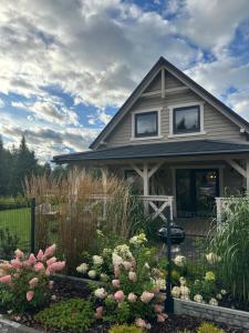 a house with a flower garden in front of it at Domki Lawendowe in Sasino