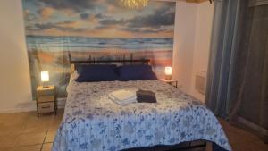 a bedroom with a bed with a painting on the wall at Chez Fatie in Listrac-Médoc +46 photos