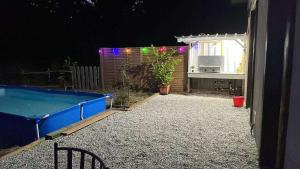 a backyard at night with a swimming pool at Chez Fatie in Listrac-Médoc