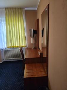 a hotel room with a desk and a mirror at Hotel Wahlster in Saarbrücken