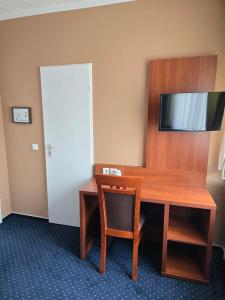 a room with a desk and a chair and a door at Hotel Wahlster in Saarbrücken